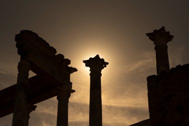 Merida 'daki Roma Tiyatrosu' nun başkentlerinden, köşelerinden ve sütunlarından, gün batımında arka planda güneş ışığıyla aydınlanan manzara sütun başkentinde ilahi bir parıltı yaratıyor..