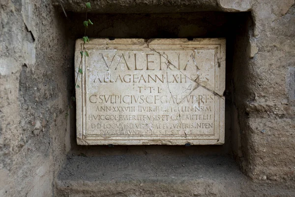 Ancient Roman inscription in marble from a funerary tombstone of Publius Valerius Laetus, which reads: Licensed soldier, 80 years old. Here he lies. May the earth be light to you.in Merida Columbarios