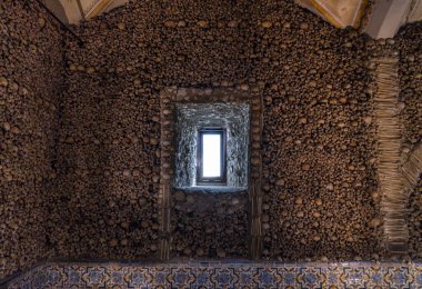 Çerçeve, pencere ve kilise duvarı Portekiz 'in Evora şehrinde bulunan Kemik Şapeli' nin insan kemikleri ve kafataslarıyla süslenmiş. Üç Fransisken rahibin girişimiydi..