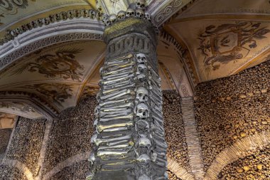 İnsan kemikleri ve kafatasları ile kaplanmış ve süslenmiş bir sütun ve Kemik Şapeli 'ndeki dini alegorik tablolarla dolu bir tavan. Evora, Portekiz.