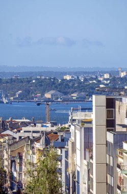 Lizbon 'da bir caddenin üstünden Tagus Nehri' ne iskele vinçleri, depoları ve deniz trafiği olan panoramik manzara.