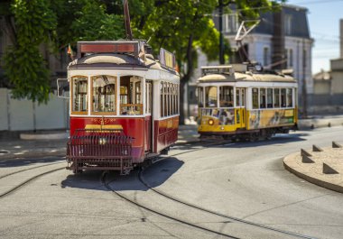 Ünlü ve tipik klasik eski kırmızı tramvay, güzel dekore edilmiş ve Portekiz 'deki tipik bir Lizbon caddesinde raylarda çalışan orijinal tasarımları muhafaza ediyor. Arkasında sarı bir tramvay daha var..