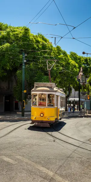 有名で典型的な古い黄色いトラムは 美しく装飾され ポルトガルの典型的なリスボン通りの線路に沿って旅行するオリジナルのデザインを保存します — ストック写真