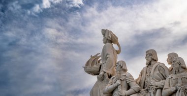 Doğuda kireçtaşından heykeller ve elinde Gezgin Henry 'nin elinde Lizbon' daki Keşifler Anıtı 'ndan olağanüstü bulutlu mavi gökyüzü olan bir gemi var..