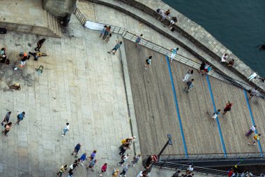 Douro Nehri üzerindeki Dom Luis Ribeira Köprüsü 'nün Porto gezinti alanı boyunca yürüyen ve fotoğraf çeken insanların, turistlerin ve ailelerin hava manzarası..