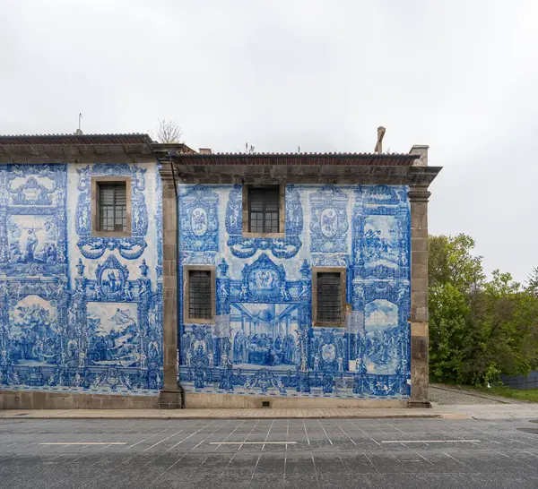 stock image Facade of the lateral part of the Chapel of the Souls or Chapel of Saint Catherine of Oporto, decorated with blue and white tiles with religious motifs. Wrought iron windows. Portugal.