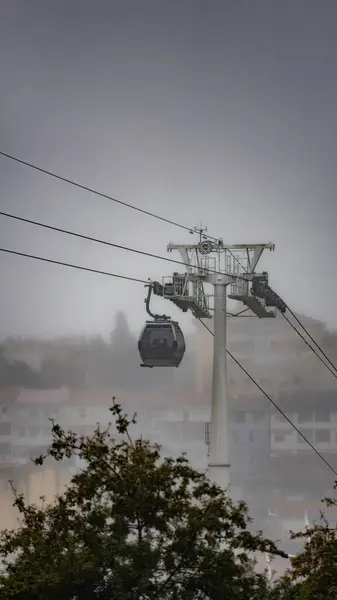 一辆Vilanova Gaia缆车吊挂在悬挂的钢丝绳上 在乌云密布的天空中上升 典型的Gaia街区笼罩在雾中 — 图库照片
