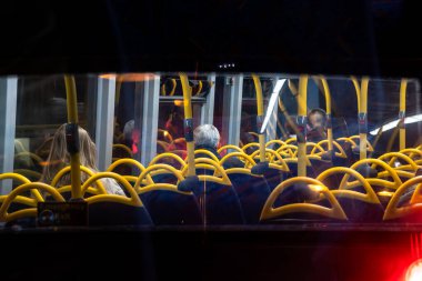 Londra 'daki çift katlı bir otobüsün arka camından geceleyin Londra' nın orta caddesinde seyahat eden yolcuların görüntüsü..