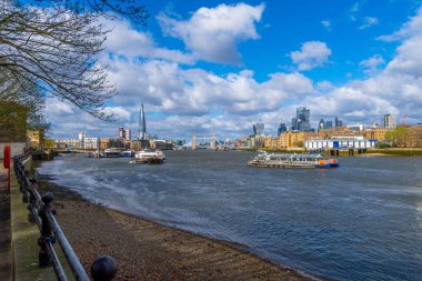 Thames Nehri 'nin Rotherhithe Gezinti Güvertesi' nden panoramik manzarası Tower Bridge, The Shard gibi Londra gökdelenleri ve nehir boyunca giden gemi trafiği ve turist feribotları.