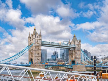 Londra 'daki Tower Köprüsü feribot rıhtımından Thames Nehri' ne kadar. Nehir ve karayolu trafiği boyunca giden nakliye trafiği ve köprü yolunda seyahat eden Londra otobüsleri..
