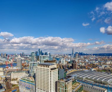 Ünlü Londra binalarının ve gökdelenlerin panoramik hava manzarası, finans bölgesi, şehir silueti, ticari ofis binaları, modern mimari ve tren istasyonu.