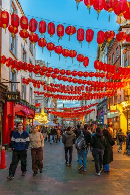 Yaya ve turistler Soho 'da Çin Mahallesi' nde bir cadde boyunca yürüyorlar ve duvarlara bağlanmış kırmızı Çin fenerleri ya da kağıt fenerler var..