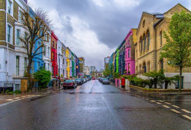 Lancaster Yolu 'ndaki Notting Hill Mahallesi' nde yağmurlu bir gün. Viktorya tarzı evlerin efsanevi caddesi. Caddenin asfaltındaki evlerin renginin yansıması..