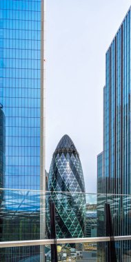 Gökdelenden gökdelenlere bakan bir gökdelenden 30 St. Mary Axe gökdelenine yüksekten bir manzara, ayrıca Londra Yumurtası ya da Şehrin İncisi olarak da bilinir, burada bir işçi cam cepheyi temizliyor..