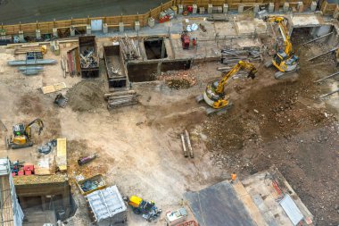 Aerial view of a construction site and building site with heavy machinery in operation in London's city centre financial district. Urban excavations in a commercial area. clipart