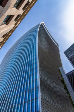 Londra şehrinin modern mimarisi ikonik eğimli gökdeleniyle 20 Fenchurch Sokağı aşağıdan muhteşem bir manzarayla ve açık mavi gökyüzü ile güneşli bir günde Walkie-Talkie olarak da bilinir..