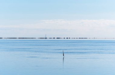 Karavan hattı, bir yelkenli ve gezinen insanlar Ebro Delta, Akdeniz 'deki Trabucador sahilinin sakin sularına yansıdı..