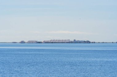 Bahia de los Alfaques tuz madeninde kristalize tuz yığınları Akdeniz 'in sakin mavi sularında Ebro Delta' da deniz tuzu arıtıldığı yerde..