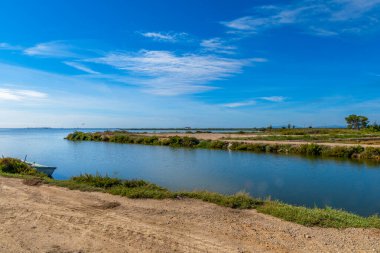 Ebro Delta 'nın sakin suları ve arka planda sahili olan doğal manzarası ve arka planda bir karavan ile Fata Morgana' nın görsel efekti..
