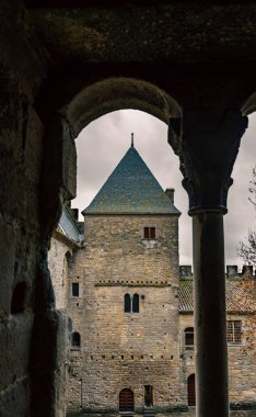 Medieval stone tower framed by an arch on a cloudy day in Carcassonne. clipart