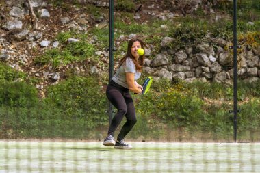 Genç, atletik ve kaslı bir kadının kale kenarındaki ağdan topu ters vurarak ona doğru gelen bir pozisyonda bir bakış açısı..