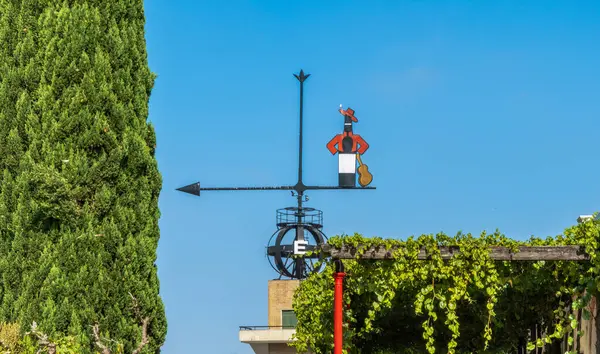 Tio Pepe 'nin efsanevi figürüyle dekoratif rüzgar gülü çatıda mavi gökyüzüne karşı flamenko gitarist olarak bir şişe tutuyor..