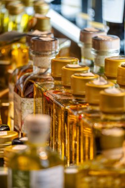 Özel üretim ürünleri satan bir marketin rafında gurme zeytinyağı şişeleri sergileniyor..