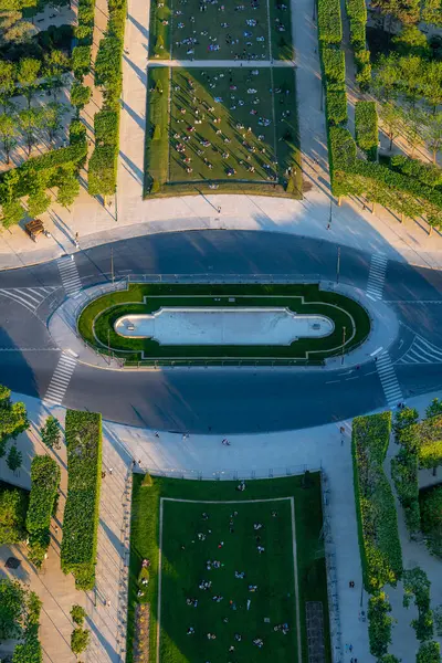 Paris 'teki Champ de Mars Parkı' nın muhteşem hava manzarası. İnsanlar gün batımında çimlerin üzerinde dinleniyor, yemek yiyor ya da fotoğraf çekiyor..