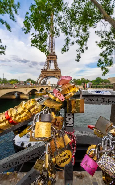 Paris 'teki Seine Nehri' nin yanındaki korkuluklara yazıtlı aşk kilitleri konur. Arka planda Eyfel Kulesi ve Pont des Arts bulunur..