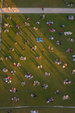 Uzun gölgeleri günbatımında Champ de Mars 'ın yeşil çimlerine yansıyan insansız hava araçları pikniklerin ve romantik akşam yemeklerinin keyfini çıkarıyor..