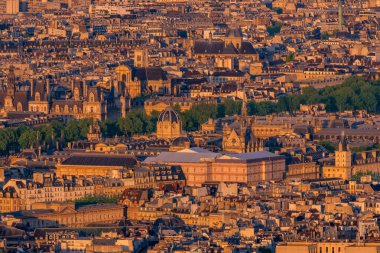 Fransa 'nın orta kesimindeki Paris' te gün batımının altın saatinde Paris 'in yoğun çatıları ve Sainte Chapelle gibi tarihi binaların panoramik manzarası.