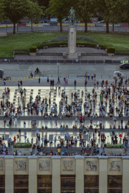 Güneşli bir günde Paris 'teki Trocadero Meydanı' ndaki basamaklarda ve merdivenlerde toplanan turist ve yerli halk kalabalığı görülüyor..