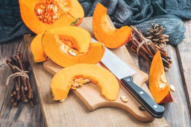 Sonbahar mevsimi balkabağı baharat pişirme ve içecekleri içme. Renkli balkabakları, fındıklar, mevsimlik baharatlar. Balkabağı turtası, latte, sonbahar Şükran Günü tatili için kurabiyeler. Tahta masada balkabağı.