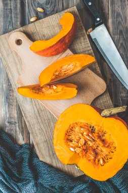 Ahşap bir arka planda balkabakları. Sarı sonbahar hasat balkabakları şenlik masasında. Sonbahar tatilleri, cadılar bayramı, Şükran Günü, yemek konsepti. Kesme tahtaları ve balkabaklarıyla dolu mutfak.