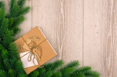 Noel kartı için koni kozalaklı köknar ağacı sınırı, mesaj için kopya alanı. Mutlu yıllar konsepti. Tatil günü. Noel modeli mi yoksa tebrik kartı mı? Üst manzara, düz yatış. Kozalaklı dallar ve bir hediye.