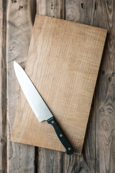 cutting board on a wooden table. Kitchen utensils. Empty place. Top view. Food recipe concept at wood background texture with copy space. Empty table. Empty board background.