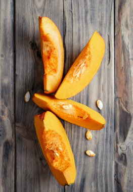 Şükran Günü. Kabaklar ahşap arka planda. Taze turuncu, büyük bir balkabağı ve tahta tahtada bir dilim balkabağı, yaklaşın. Organik sebze ürünleri, yemek malzemeleri, sağlıklı gıda vejetaryeni..