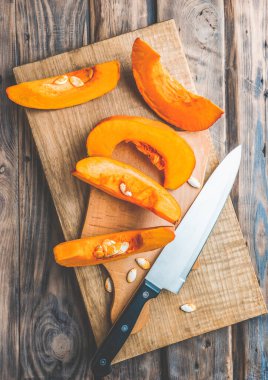 Sonbahar mevsimi balkabağı baharat pişirme ve içecekleri içme. Renkli balkabakları, fındıklar, mevsimlik baharatlar. Balkabağı turtası, latte, sonbahar Şükran Günü tatili için kurabiyeler. Tahta masada balkabağı.