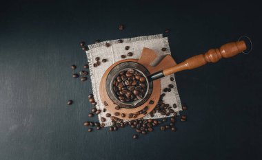 Kahve çekirdekleri. Farklı kahve, fasulye ve tarçın çeşitleriyle kavrulmuş kahve kavramı koyu siyah taş arka planda. Üst Manzara. Kahve konsepti. Model yap. Kahve zamanı. Kahve molası.