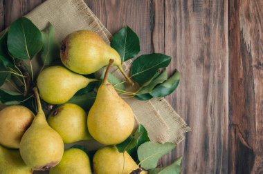 Yapraklı taze armut. Tepside taze armut. Ahşap arka planda. Taze inciler. Yazı için yer var. Üst manzara, düz yatış. Kopyalama. Pankart.