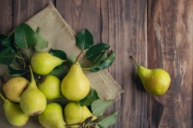 Armutlar. Tahta kutuda yaprakları olan taze organik armutlar veya eski koyu gri arka planda sepet. Sonbahar meyve hasadı. Üst Manzara. Yemek arkaplanı. Üst manzara, düz yatış. Kopyalama. Pankart.