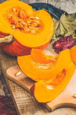 Sonbahar mevsimi balkabağı baharat pişirme ve içecekleri içme. Renkli balkabakları, fındıklar, mevsimlik baharatlar. Balkabağı turtası, latte, sonbahar Şükran Günü tatili için kurabiyeler. Tahta masada balkabağı.