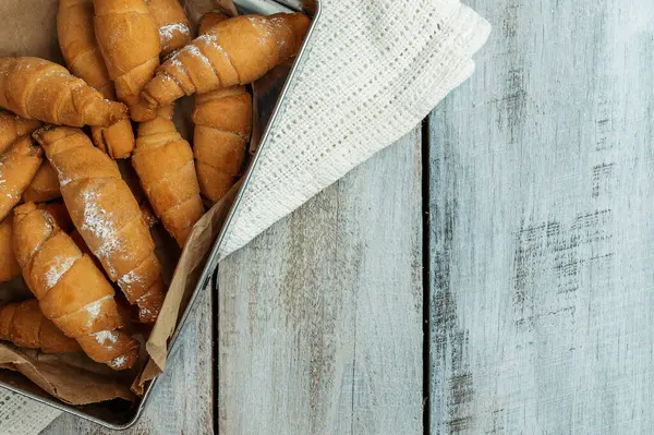 Peynirli taze kruvasan. Kahvaltı için geleneksel ev yapımı Fransız hamur işleri. Pişmiş tatlı kruvasan. Tahta masada taze kruvasanla nefis bir kahvaltı. Çörekler. Ev yapımı pişirme..