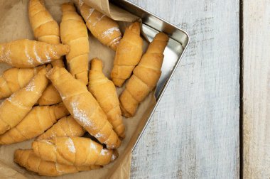 Peynirli taze kruvasan. Kahvaltı için geleneksel ev yapımı Fransız hamur işleri. Pişmiş tatlı kruvasan. Tahta masada taze kruvasanla nefis bir kahvaltı. Çörekler. Ev yapımı pişirme..