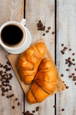 Kırsal ahşap bir masada ayçöreği olan kahve fincanı. Yiyecekler. Lezzetli taze kruvasanlar. Taze pişmiş hamur işiyle servis edilen kıtasal kahvaltı. İyi sabahlar. Kahve taneleri. Kahve çekirdekleri..