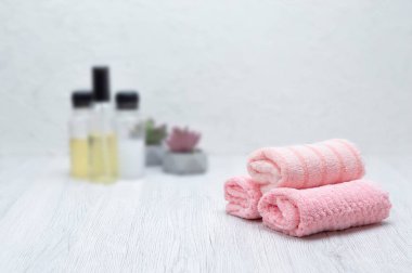 Pembe havlular, şampuan, saç kremi ve sabun banyoda temiz bir yan görünüme ve kopyaya yer var..