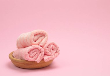 Açık arkaplanda yumuşak pembe katlanmış havlular, metin ve logolar için alanı olan tasarım projeleri ve modeller için idealdir..