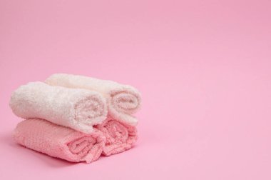 Pembe kabarık havlular ışıkta katlanmış, tasarım ve markalaşma için temiz telif alanı sunuyor.