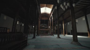 Kamera, tarihi tahta Seljuk camisinde geriye doğru hareket ediyor. Kapıdan dışarı adımını attığında, sanatsal dekorasyonlar gözüne çarpıyor..