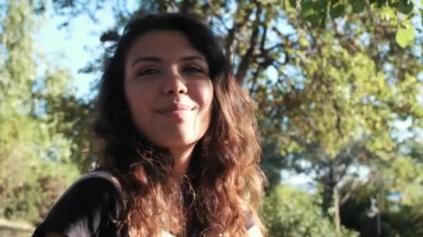 Kadın Gün Batımında Döner Kameraya Bakar Gölgeli Işıkta Yeşillikte — Stok video